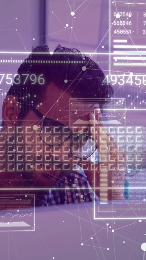 Vertical video: Man at desk seeing AR pop-up, rubbing temple, adjusting glasses, Stock Footage 330509823