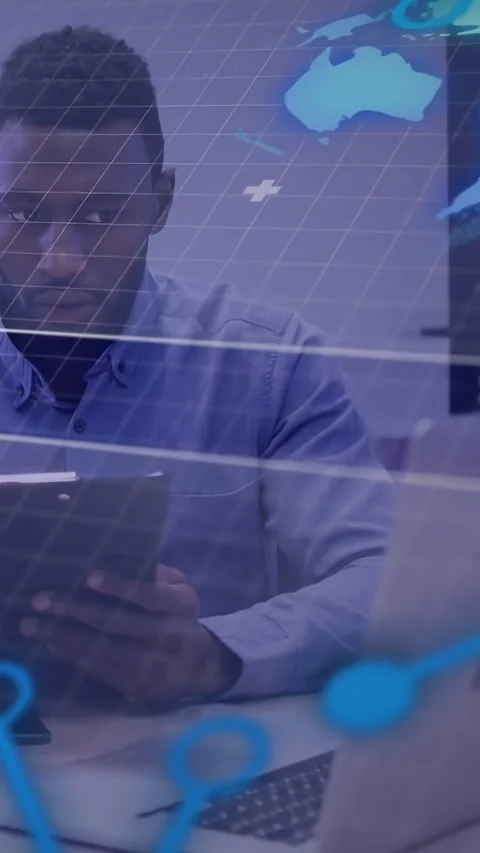 Vertical video: Man at desk tapping tablet, glancing, activating map overlay and Stock Footage 334550410