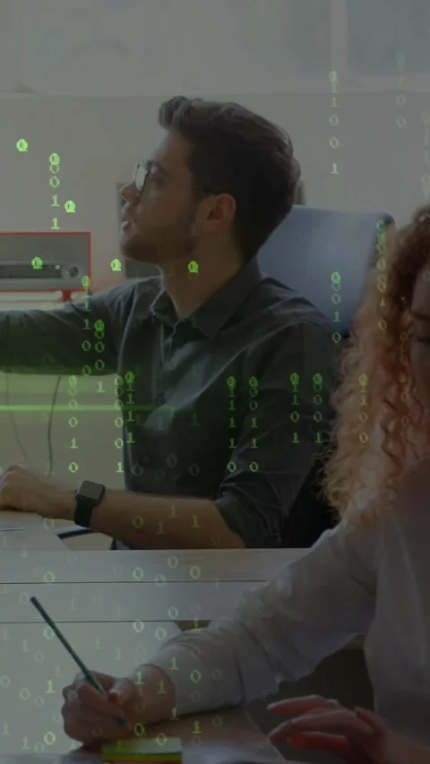 Vertical video: Man at desk typing, glancing as tech binary layer rising, Stock Footage 334598853