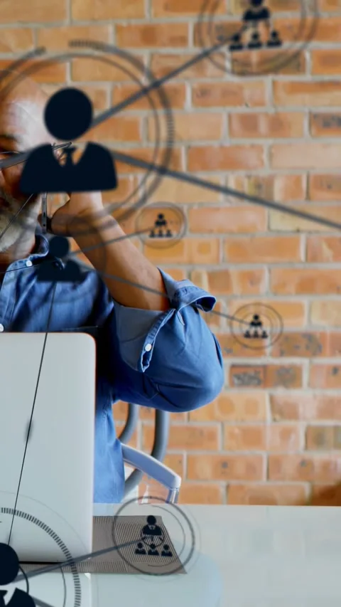 Vertical video: Man at desk using phone, call starting nodes sweeping laptop Stock Footage 334397467