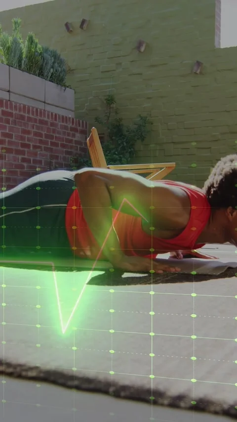 Vertical video: Man doing pushups on mat via pulsing green waveform guiding Stock Footage 333465098