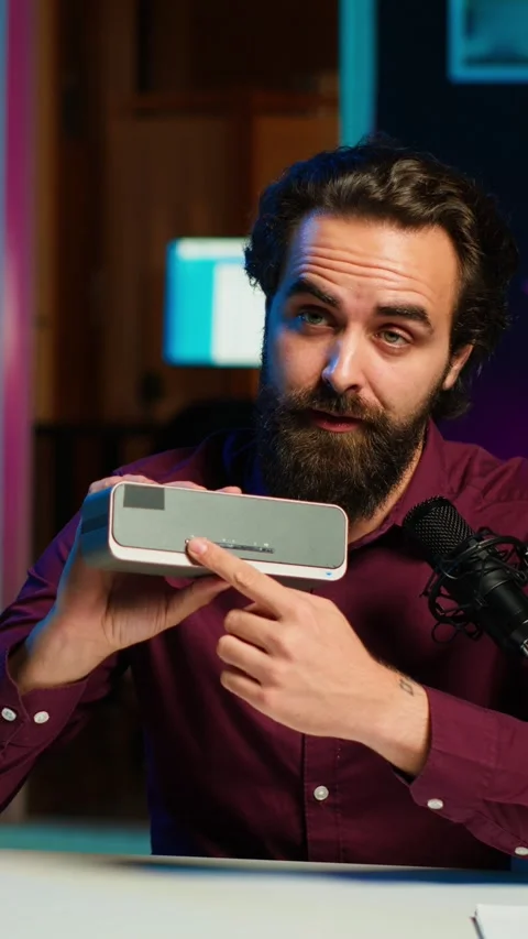 Vertical video Man doing technology review of wireless portable speaker Stock Footage 311003123