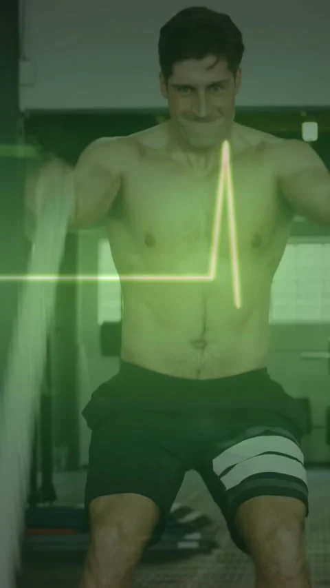 Vertical video: Man driving ropes down, producing waves for cardio, ECG overlay Stock Footage 330542830