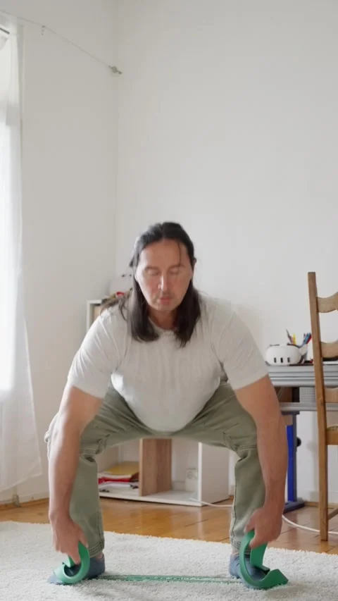 Vertical video. A man is engaging in resistance band exercises aimed at Stock Footage 311052354