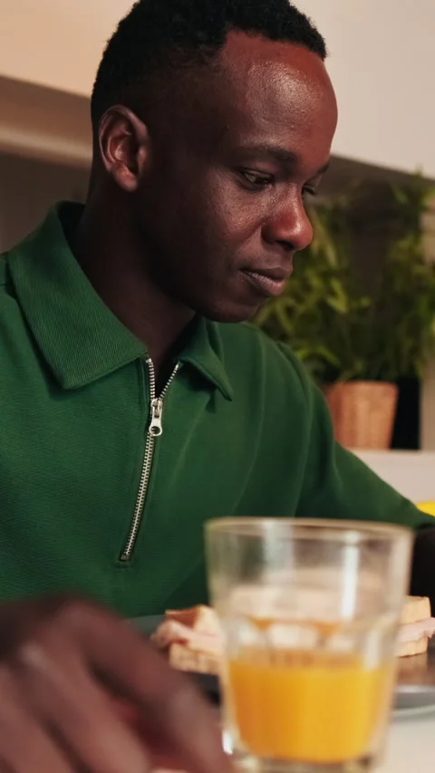 Vertical video, Man Enjoys Breakfast and Checks Phone Stock Footage 305954431