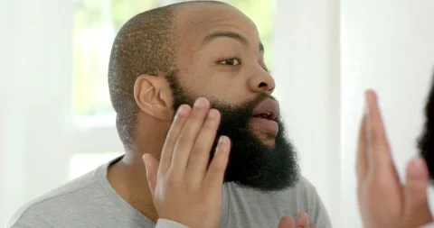 Vertical video: Man facing mirror starting grooming, pressing and shaping beard Stock Footage 339272610