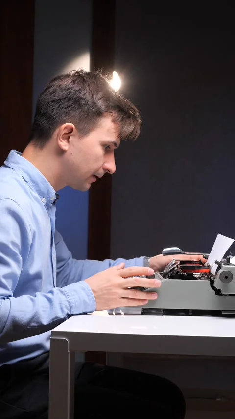 Vertical video Man focusing on an old manual typewriter, gesturing with his hand Stock Footage 321621294