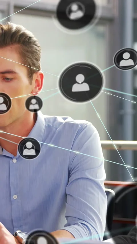 Vertical video: Man gesturing at table, causing network icons to grow, mapping Stock Footage 334386705