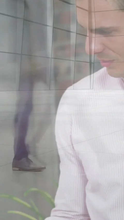 Vertical video: Man glancing away, lifting laptop to work on tech, with glass Stock Footage 334604877