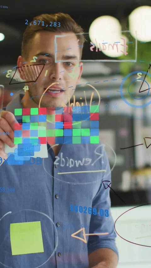 Vertical video: Man at glass placing note on RGB grid while woman writing green Stock Footage 333259943