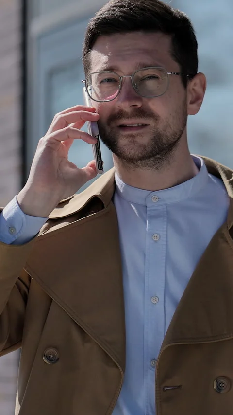 Vertical video. Man in glasses having phone talk outdoor. Stock Footage 345234518