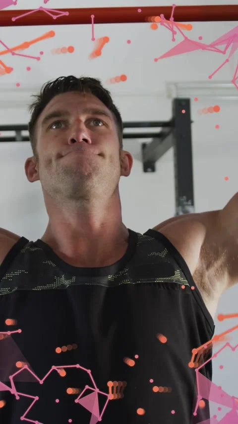 Vertical video: Man grabbing red bar doing pullups while training, pink overlay Stock Footage 333174859