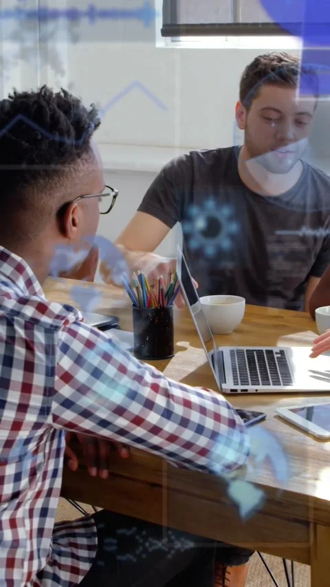 Vertical video: Man in gray tee pointing at laptop and causing blue tech graphs Stock Footage 334382591