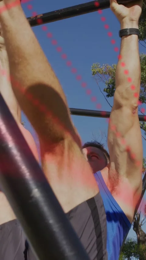 Vertical video: Man gripping pull-up bar doing repeated leg raises for fitness Stock Footage 333487372