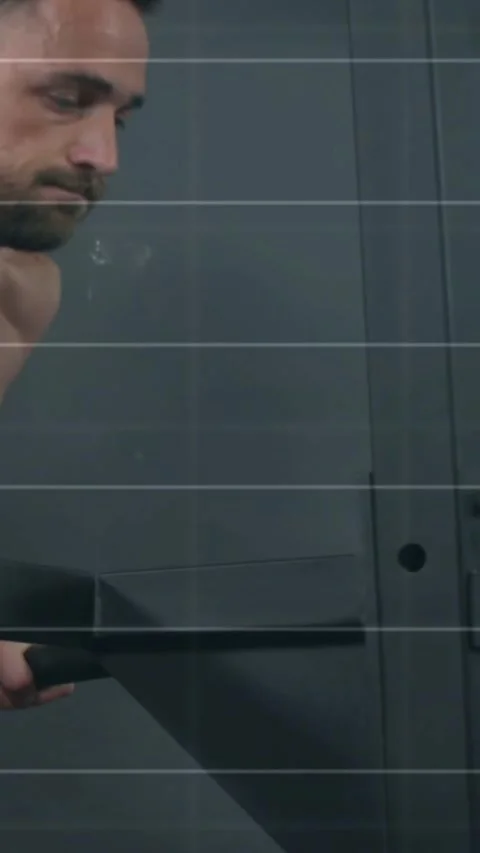 Vertical video: Man gripping squeegee and wiping glass door, motion lines 스톡 동영상 334541258