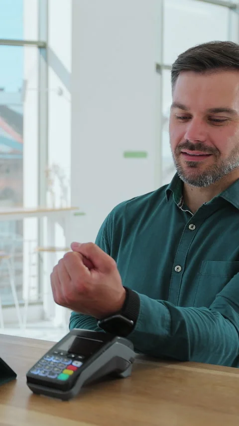 Vertical video. Man hand with smartwatch using terminal for payment in coffee Stock Footage 343768423