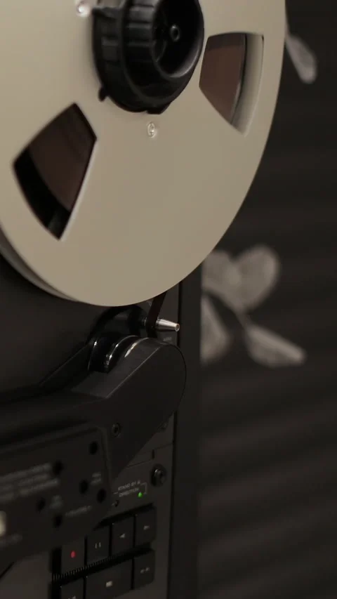 Vertical video Man hand turns on music on reel to reel tape recorder playing. Stock Footage 338082959