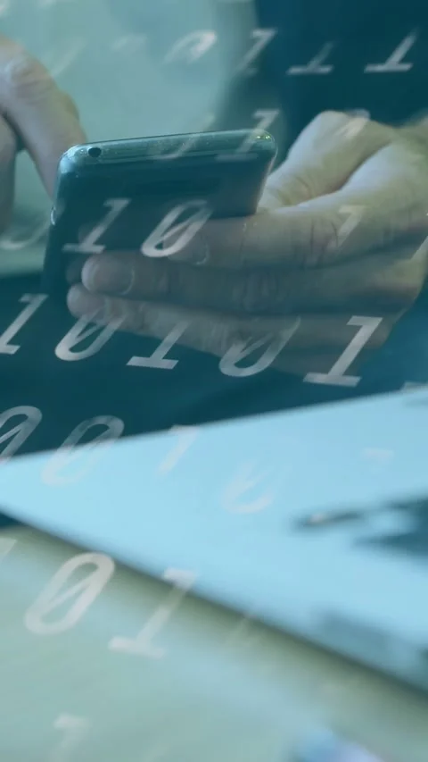 Vertical video: Man holding cell over pc tapping screen while 01 overlay moving Stock Footage 333480554