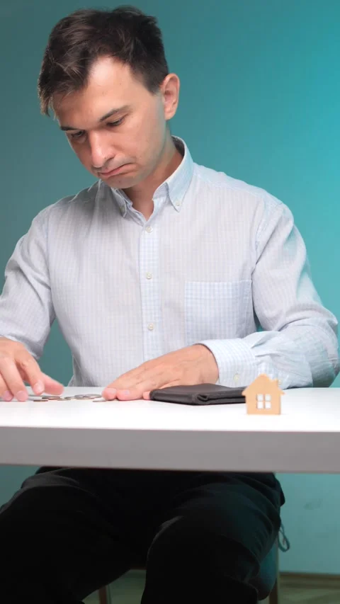 Vertical video man holding an empty wallet and looking at a small pile of coins Stock Footage 342762414