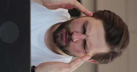 Vertical video: Man holding hands, massaging forehead and head with severe pain Stock Footage 271505044