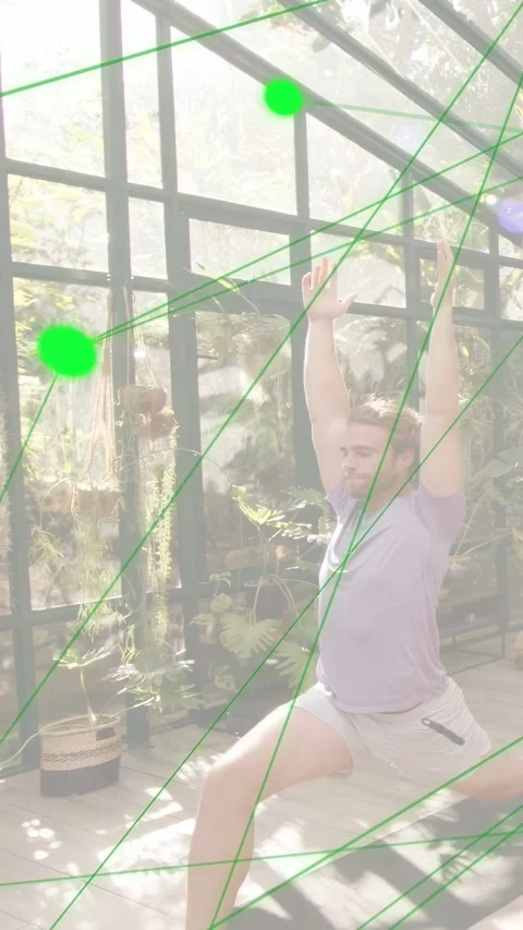 Vertical video: Man holding high lunge in greenhouse, causing green node network Stock Footage 333840357