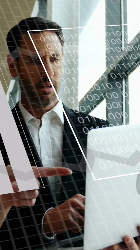 Vertical video: Man holding laptop by windows using pad, animating tech graphs Stock Footage 333222060
