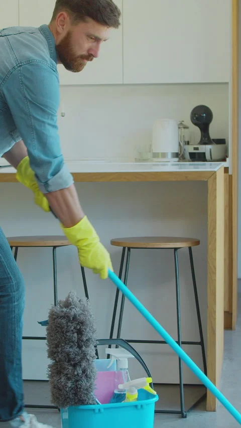 Vertical Video Man holding mop and plastic bucket with brushes Stock Footage 337994484