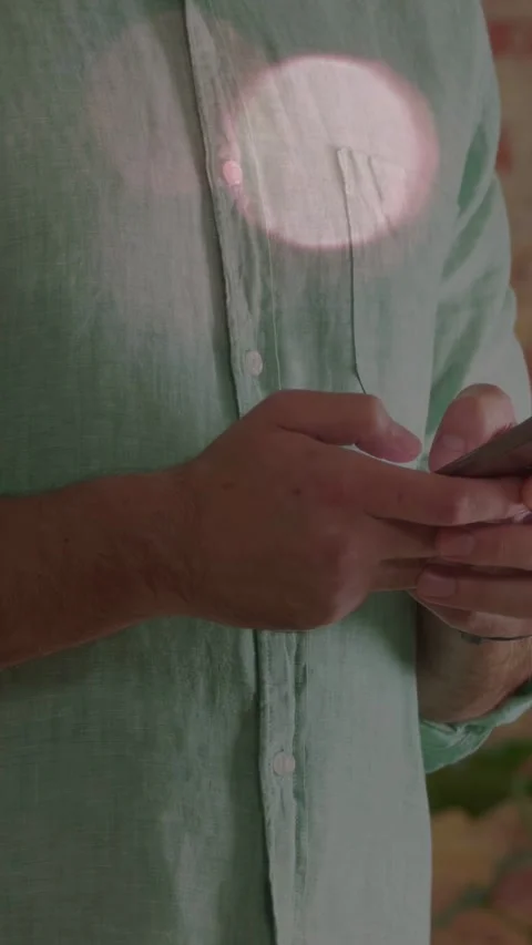 Vertical video: Man holding phone tapping thumbs, starting scrolling for tech Stock Footage 334297666