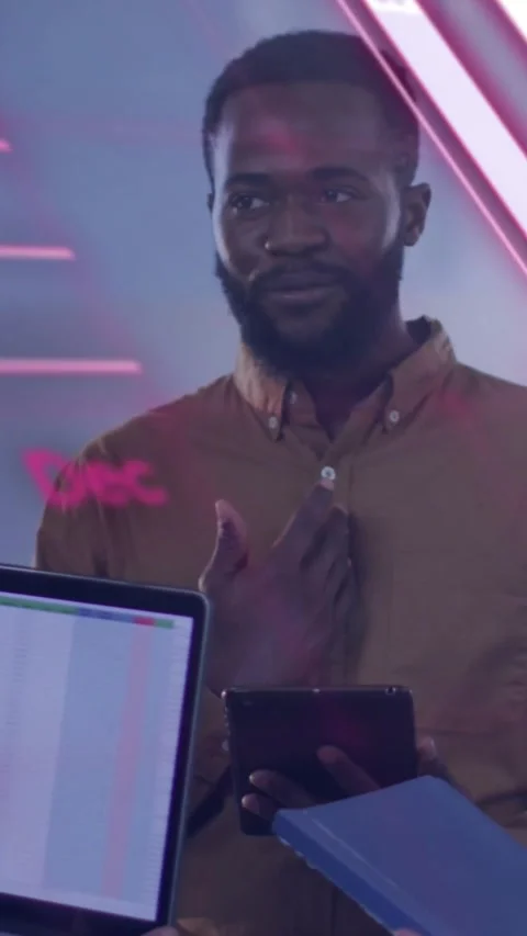 Vertical video: Man holding tablet and gesturing in office activating pink bars Stock Footage 334319486