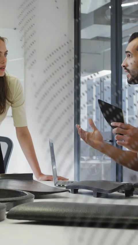 Vertical video: Man holding triangle part, starting design, woman leaning in, Stock Footage 332823597