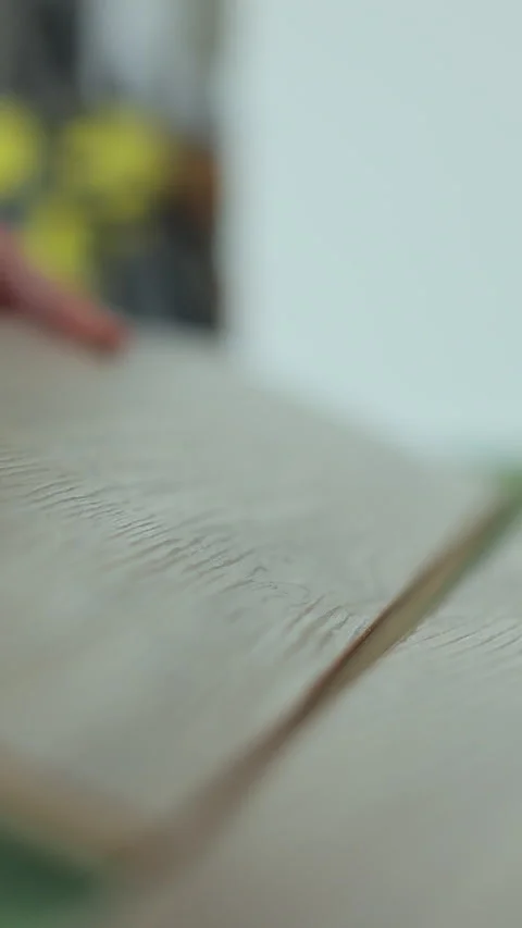 Vertical video Man kneeling and installing wood laminate floor in a home. 스톡 동영상 339060657