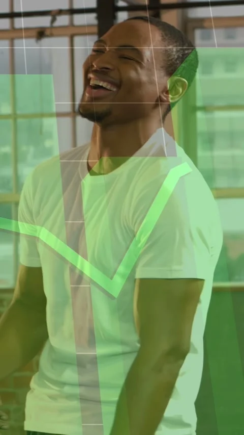 Vertical video: Man laughing, tilting in loft as left cue moving green chart Stock Footage 333036947