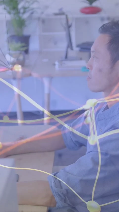 Vertical video: Man leaning at desk, responding to monitor alert, technology Stock Footage 333496335