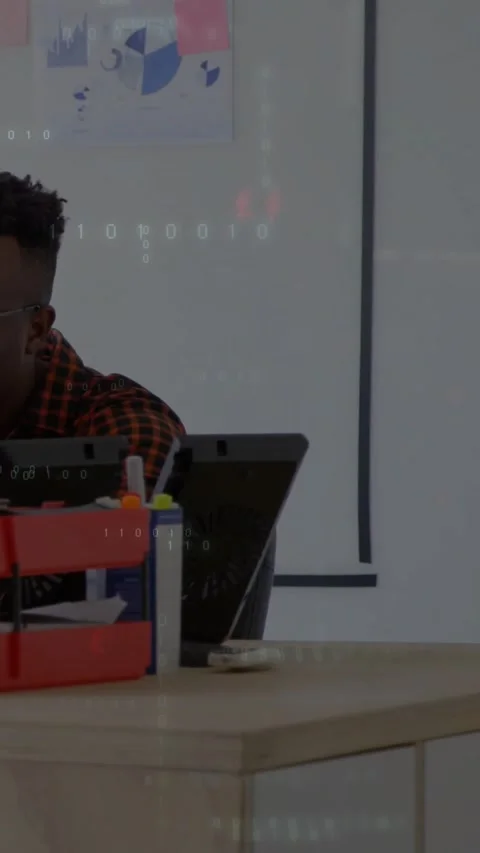 Vertical video: Man leaning in at desk reading code for IT while data overlays Stock Footage 334397027