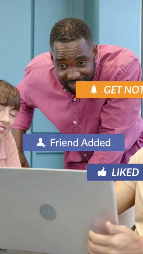 Vertical video: Man leaning over laptop as peer tapping play, causing social Stock Footage 334377973