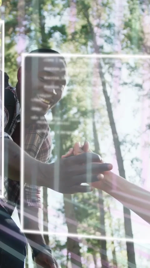 Vertical video: Man leaning, reaching, helping other up, hands clasping as AR Stock Footage 333861990