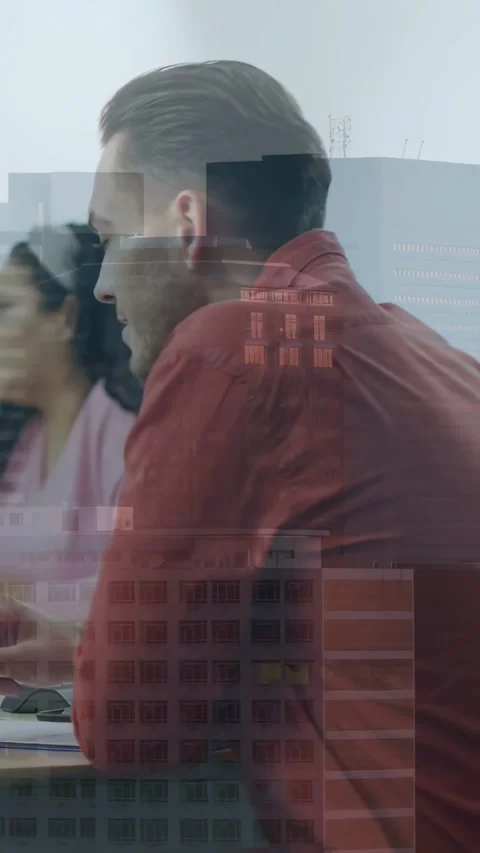Vertical video: Man leaning toward laptop reviewing tech data, facade overlay Stock Footage 334187119