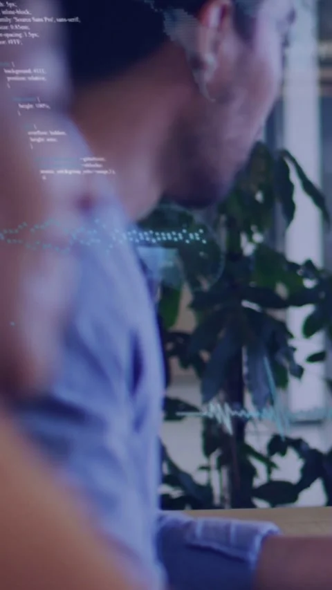 Vertical video: Man leaning, typing at desk and creating code overlay, waveform, Stock Footage 334601294