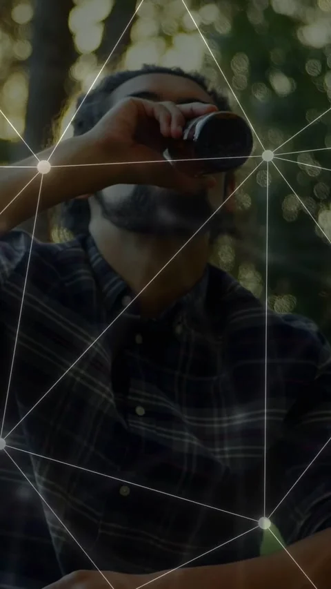 Vertical video: Man lifting bottle to lips and sipping at park meetup node Stock Footage 333913016