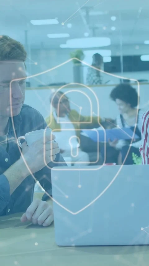 Vertical video: Man lifting mug and looking at laptop, sparking cyber shield Stock Footage 333157437