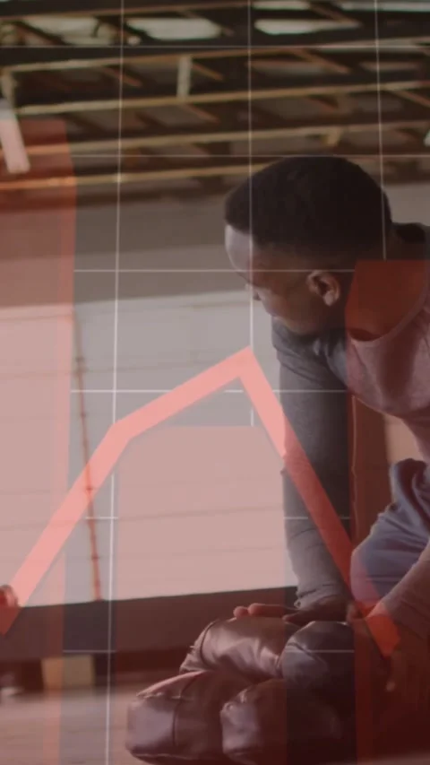 Vertical video: Man looking down and tightening gloves, training prep, red graph Stock Footage 331567546