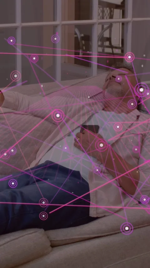 Vertical video: Man lying on sofa glancing at phone sparking purple AR nodes Stock Footage 334046999