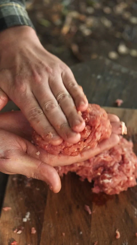 Vertical video of man makes cutlets from minced meat for burger at outdoors Stock Footage 286314467