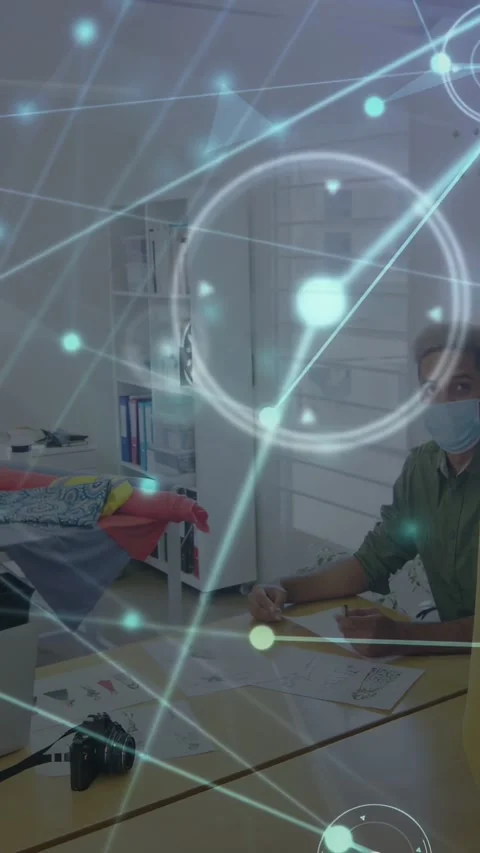 Vertical video: Man marking sketches at design table, node overlay moving left, Video stock 333079852