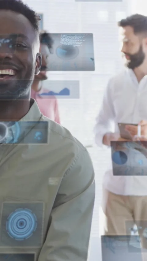 Vertical video: Man in mint shirt smiling as team tapping tablet making tech Stock Footage 334547226