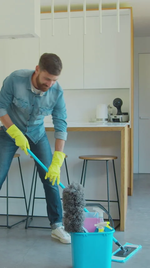 Vertical Video Man is mopping floor at home and having fun. Stock Footage 337994562