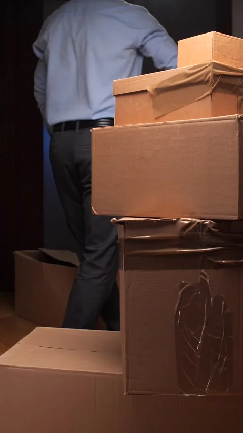 Vertical video Man moving cardboard boxes during house relocation process Stock Footage 318980555