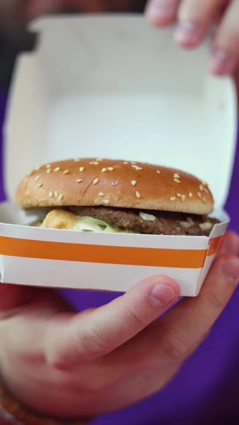 Vertical video. Man opens box with Big Mac burger with McDonald's logo Vídeos de archivo 340427633