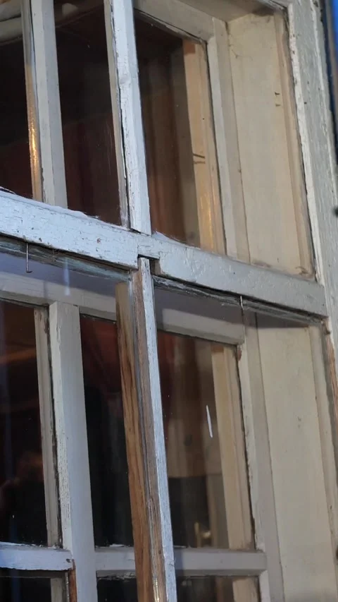 Vertical video a man opens old wooden shutters outside an old rural house Stock Footage 276239426