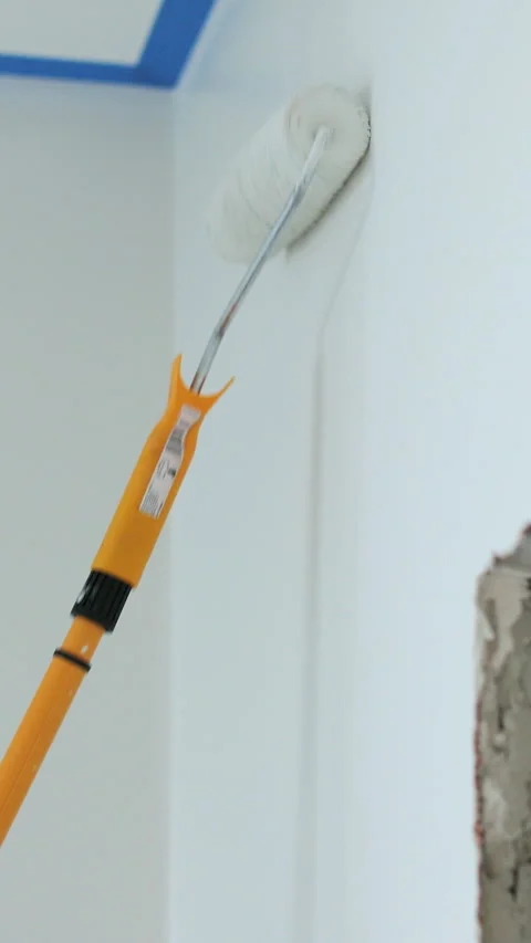 Vertical video Man painting wall in white color with roller. Stock Footage 339060099